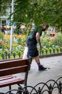 Фото татуировки на спине мужчины: листья марихуаны, черепа и другие элементы. Уличная фотография.