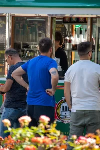 Фото татуировки на руке мужчины с изображением серой короны и надписью 'freedom'. Уличная татуировка, сделанная опытным мастером.