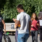 Фото тату на предплечье мужчины: якорь, обвитый розой, выполнен в черно-серых тонах. Детализированный рисунок татуировки с четкими контурами.