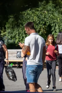 Фото тату на предплечье мужчины: якорь, обвитый розой, выполнен в черно-серых тонах. Детализированный рисунок татуировки с четкими контурами.