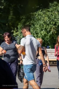 Фото татуировки на руке мужчины: детализированный рисунок, включающий в себя череп, цветы и другие элементы в черно-серых тонах. Реалистичный стиль татуировки.