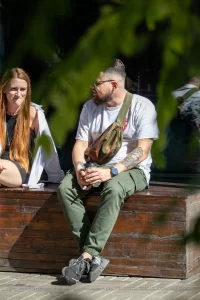 Фото тату на предплечье мужчины: детализированный рисунок корабля, якоря и морских волн в черно-серых тонах. Морская тематика татуировки.