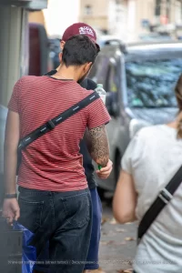 Фото татуировки на руке мужчины, выполненной в стиле трайбл. Рисунок представляет собой сложный орнамент из черных линий и геометрических фигур.