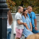 Фото мужчины с татуировкой спирали на руке, одетого в серую футболку. Татуировка выполнена в черном цвете и имеет минималистичный дизайн.