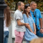 Фото мужчины с татуировкой спирали на руке, одетого в серую футболку и розовые шорты. Татуировка выполнена в черном цвете.