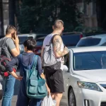 Фото тату на руке мужчины: детализированный черно-серый рисунок с японскими мотивами, карпами кои и цветами, выполненный в стиле ирреализм.