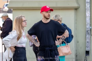 Фото тату на руке мужчины: рукав в японском стиле с изображением дракона, волн и цветов. Эскиз татуировки выполнен в черных и серых тонах с высокой детализацией.