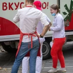 Фото тату на руке мужчины: рукав с изображением цветов и листьев, выполненный в реалистичном стиле. Эскиз татуировки демонстрирует высокую детализацию и использование черных и серых оттенков.