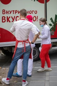 Фото тату на руке мужчины: рукав с изображением цветов и листьев, выполненный в реалистичном стиле. Эскиз татуировки демонстрирует высокую детализацию и использование черных и серых оттенков.