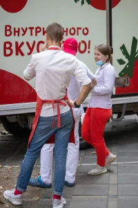 Фото тату на руке мужчины: детализированный рукав с изображением цветов, листьев и насекомых. Эскиз татуировки выполнен в реалистичном стиле с использованием черных и серых оттенков.