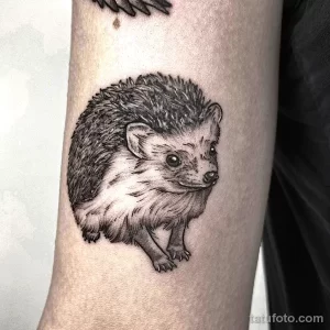 Фото простой татуировки ёжика на руке. Черно-белый рисунок с акцентом на форму и текстуру шерсти.