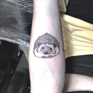 Фото минималистичной татуировки ежика в технике blackwork. Небольшой размер, четкие линии, реалистичное изображение. Идеально для любителей лаконичных и милых тату.