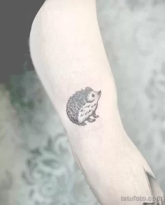 Фото минималистичной татуировки ежика в технике blackwork. Небольшой размер, четкие линии, реалистичное изображение. Идеально для любителей лаконичных и милых тату.