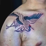 Фото тату журавля на ключице. Черно-серый рисунок, минималистичный стиль, детализированные крылья.