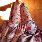 Фотография новогодних нарядов с ярким принтом в виде снежинок, елочек и Деда Мороза. Праздничный и красочный образ.