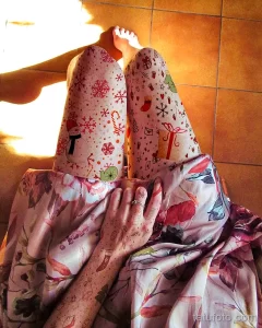 Фотография новогодних нарядов с ярким принтом в виде снежинок, елочек и Деда Мороза. Праздничный и красочный образ.