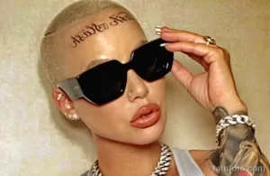 Фото тату: Amber Rose с татуировкой "Angel Nik" на голове. Иллюстрация для поиска идей тату в необычных местах.