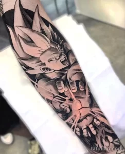 Фото тату на руке: реалистичное изображение персонажа Гоку из аниме Dragon Ball. Черно-серые тона, высокая детализация, мужская рука.