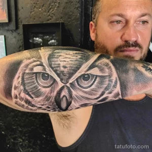 Фото тату на плече: реалистичное изображение головы совы с детальной проработкой перьев и глаз.