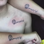 Фото тату на груди: изображение волейбольного мяча с надписью на арабском языке, выполненное в черном цвете.