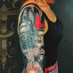 Фото тату: впечатляющая татуировка на руке, изображающая бутылку Jack Daniel's и череп. Реалистичный эскиз тату для любителей виски и рока.