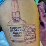 Детализированная татуировка на спине с изображением бутылки Maker's Mark. Реалистичный рисунок татуировки с прорисовкой этикетки и восковой печатью.