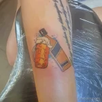Фото тату на руке: минималистичный рисунок бутылки, из которой наливается напиток в стакан, с небольшими брызгами.