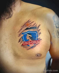 Фото тату логотипа чилийского футбольного клуба Colo-Colo на груди. Яркий рисунок с изображением вождя и надписью, символизирующий любовь к футболу.