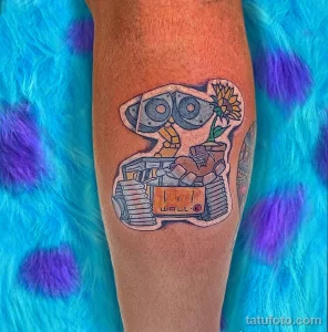 Фото тату на ноге с изображением робота WALL-E из мультфильма Pixar, выполненное в ярких и насыщенных цветах.