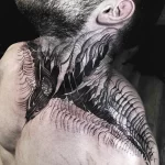 Фото тату дракона в стиле ориентал, выполненного черными чернилами на шее и плече мужчины. Детализированный рисунок с геометрическими узорами.