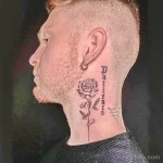 Фото тату: реалистичная роза с бабочкой и надпись "Patience" вдоль шеи. Черно-серая татуировка с детальной проработкой.