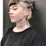 Фото тату с изображением молнии на шее. Черный контурный рисунок, выполненный в минималистичном стиле. Небольшой, но эффектный эскиз татуировки.