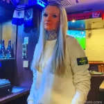 Фото тату на шее: татуировка в стиле акварель с изображением цветов и плавных переходов цветов, выполненная в нежных пастельных тонах.