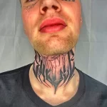 Фото тату абстрактного рисунка в стиле blackwork на мужской шее и лице. Геометрические формы и линии создают сложный узор.