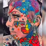Фото тату на лице женщины, изображающее яркие бабочки, цветы и сердечки. Рисунок выполнен в стиле акварель.