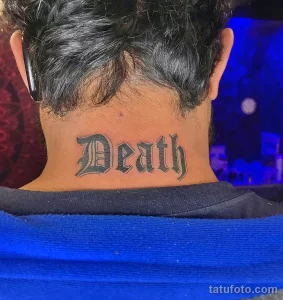 Фото татуировки надписи 'Death' на шее мужчины: выполненная в готическом стиле, черными чернилами. Смелый и выразительный дизайн.