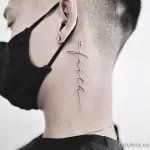 Фото тату надписи "faith" за ухом. Небольшой, изящный рисунок черными чернилами в стиле лайнуорк. Подходит для тех, кто верит в себя и свои силы.