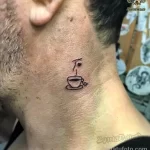 Фото тату: маленькая черная татуировка чашки кофе с паром на шее мужчины. Минималистичный рисунок татуировки в стиле лайнарт.
