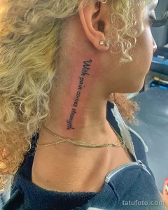 Фото тату: вертикальная надпись 'With pain comes strength' на шее женщины. Черно-белое изображение, минималистичный стиль.