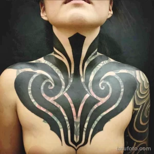 Фото тату: масштабная татуировка в стиле Blackwork, покрывающая грудь и шею. Рисунок выполнен полностью в черном цвете, с использованием сложных узоров и геометрических форм.