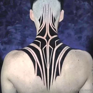 Фото тату: крупный геометрический рисунок в стиле Blackwork на спине мужчины. Татуировка состоит из черных линий и фигур, создающих сложный узор.