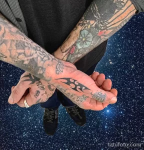 Фото тату на руках в стиле blackwork. Множество черных узоров, геометрических фигур и символов, покрывающих руки.