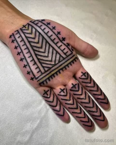 Фото тату: рунический узор на ладони, выполненный в технике blackwork. Мужской эскиз тату с древними символами.