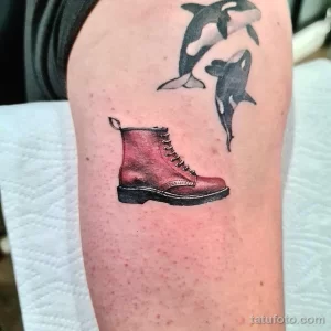 Фото тату: необычное сочетание изображения ботинка Dr. Martens и двух китов на предплечье.