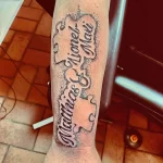Фото тату имен "Lionel & Matias" выполненных в технике dotwork, обрамленных декоративными элементами на руке.