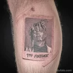 Черно-белое фото татуировки с портретом рэпера Juice WRLD на бедре. Под портретом надпись '999 FOREVER'. Реалистичный стиль, детальная проработка.