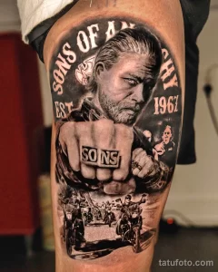 Фото тату персонажа из сериала Sons of Anarchy на руке. Детализированный черно-серый рисунок с мотоциклами и символикой байкерского клуба.