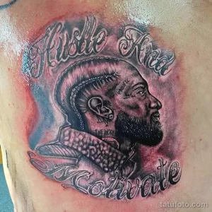 Фото татуировки на спине: портрет рэпера Nipsey Hussle. Реалистичная татуировка в черно-серых тонах.
