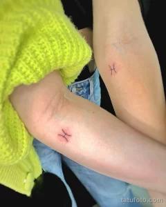 Фото парных татуировок с изображением знака зодиака Рыбы на запястьях. Минималистичный и романтичный дизайн.