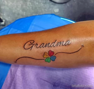 Фото тату четырехлистного клевера и надписи 'Grandma' на руке. Нежная и трогательная татуировка, посвященная бабушке.